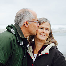 A man kissing a woman's cheek. Links to Gifts from Retirement Plans